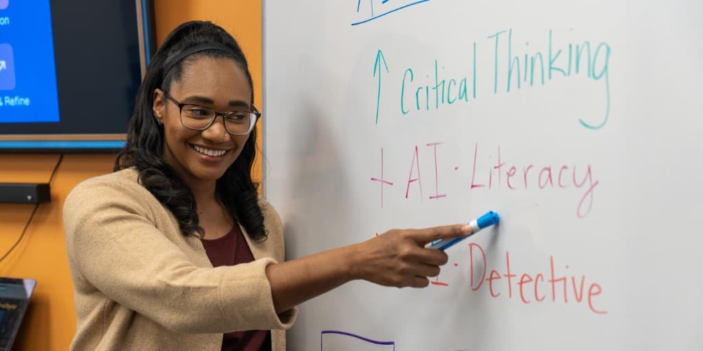 Ashley Evans at a whiteboard with notes on critical thinking, AI literacy, and AI detective skills